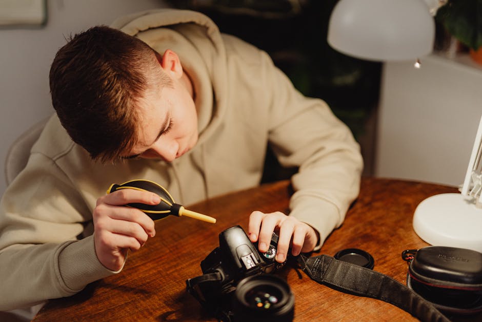 Photographer preparing to clean a camera sensor using proper tools and bright workspace light