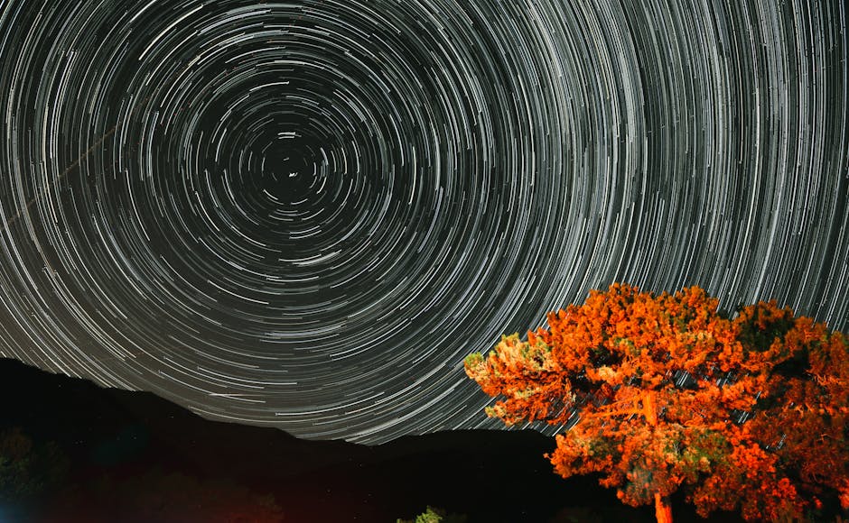 Wide-angle night landscape with visible star trails captured using an intervalometer