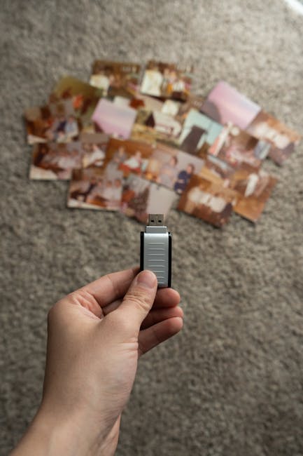 Hands organizing external SSDs and memory cards next to a camera on a desk