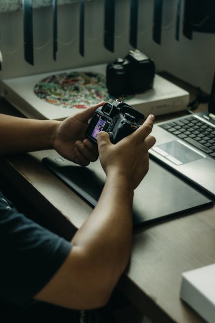 Photographer reviewing Photographer’s Cybersecurity Checklist to secure camera, laptop, cloud, and Wi‑Fi workflow.