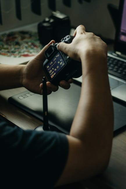 Photographer triggering a tripod camera at night using a remote shutter release