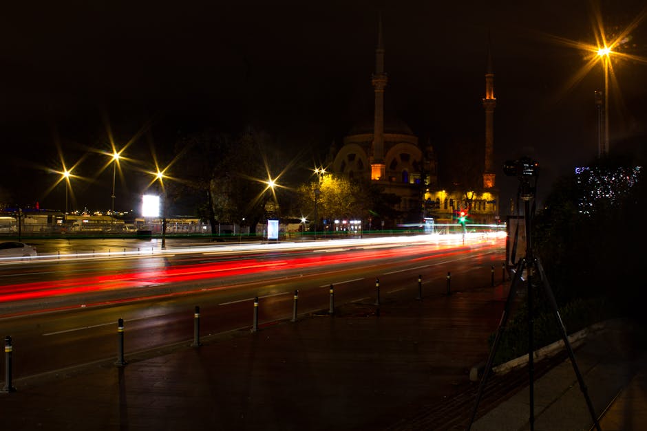 Tripod set up on a sidewalk at night with camera ready for a long exposure