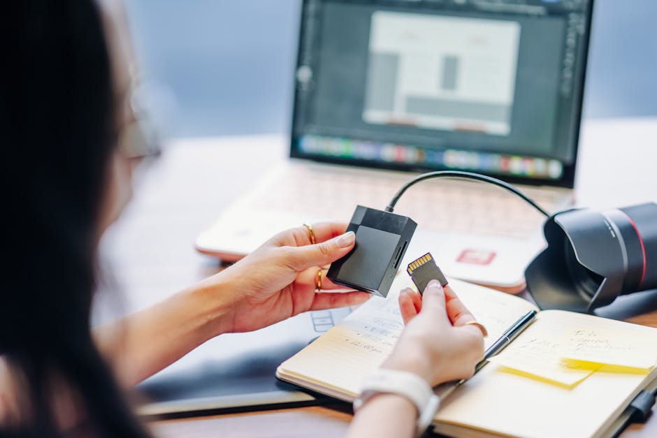 Photographer importing photos from an SD card into a laptop using a card reader
